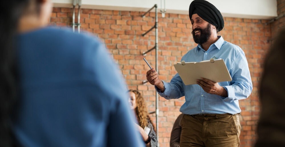 indian quality checking executive with pen and paper in hand